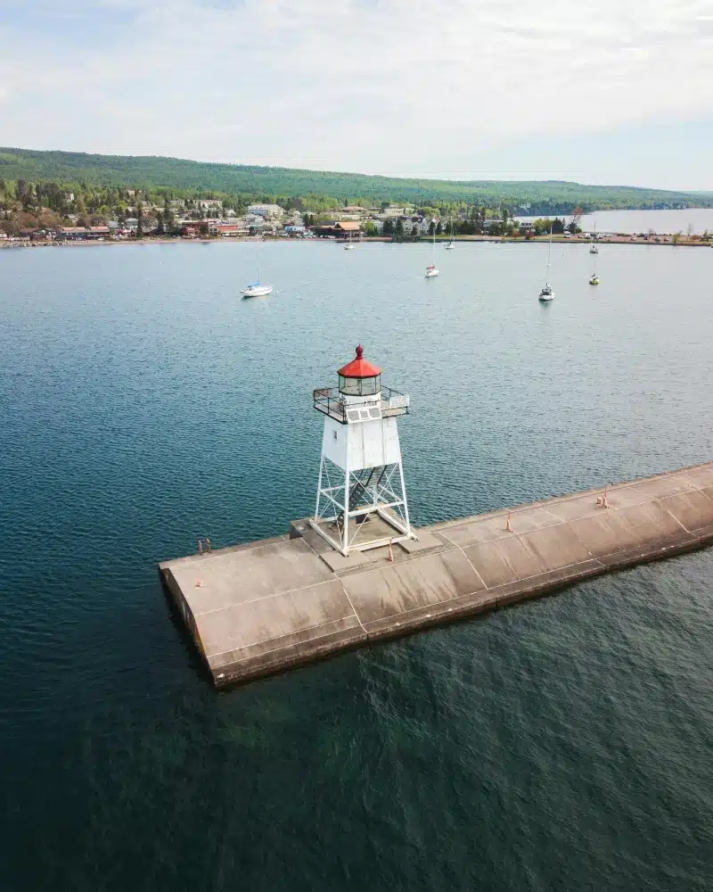 a lighthouse on a concrete walkway in grand marais minnesota
